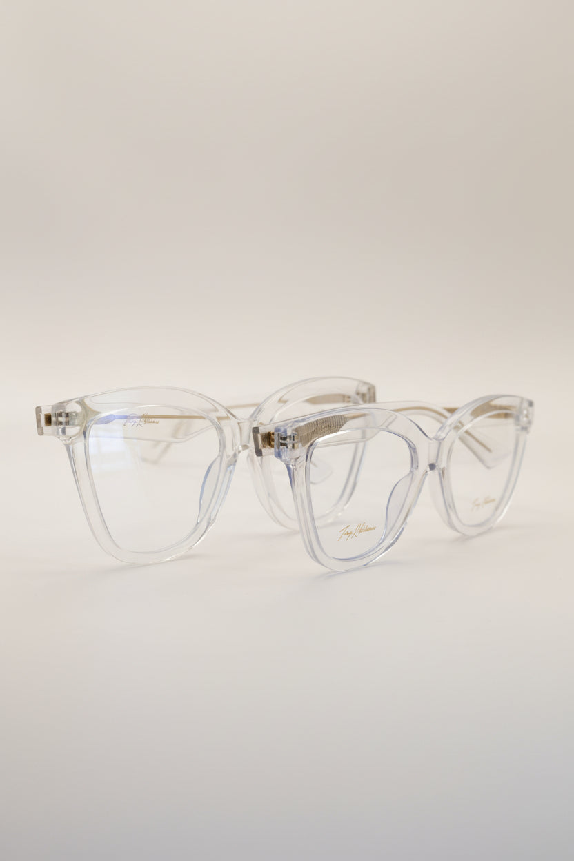 Two pairs of women's blue light glasses with clear lenses and clear frames with gold accents.