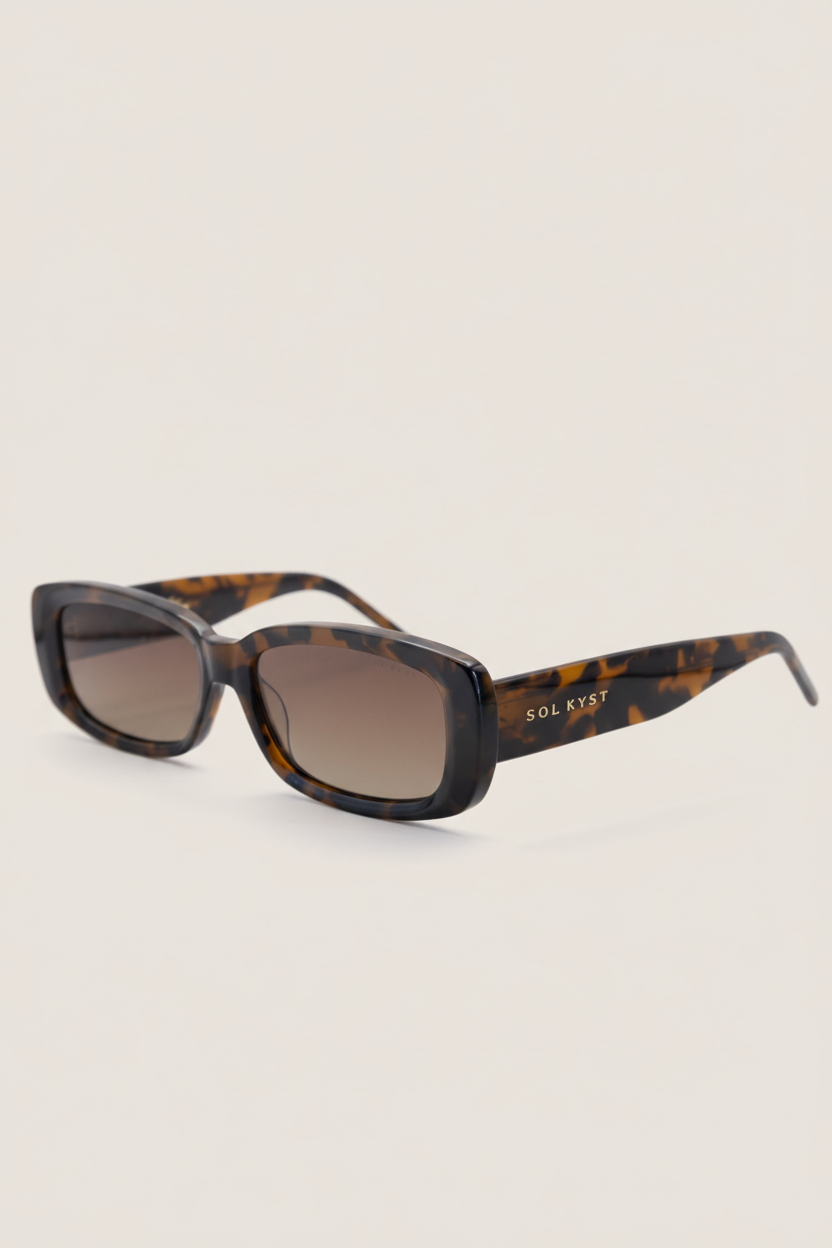 Sunglasses with tortoiseshell frame and brown lenses on a white background