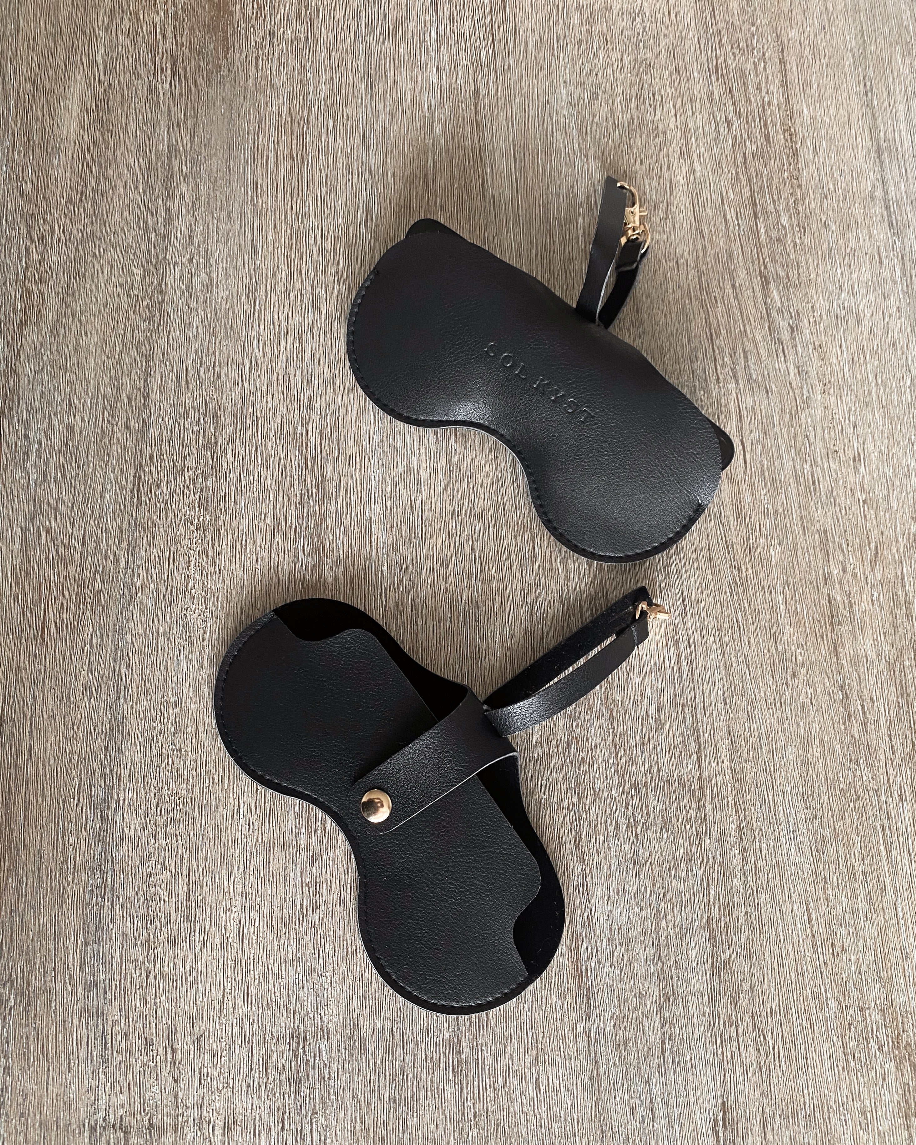 Black Sol Kyst "Kyst Klips" on textured surface, showcasing front and back views.